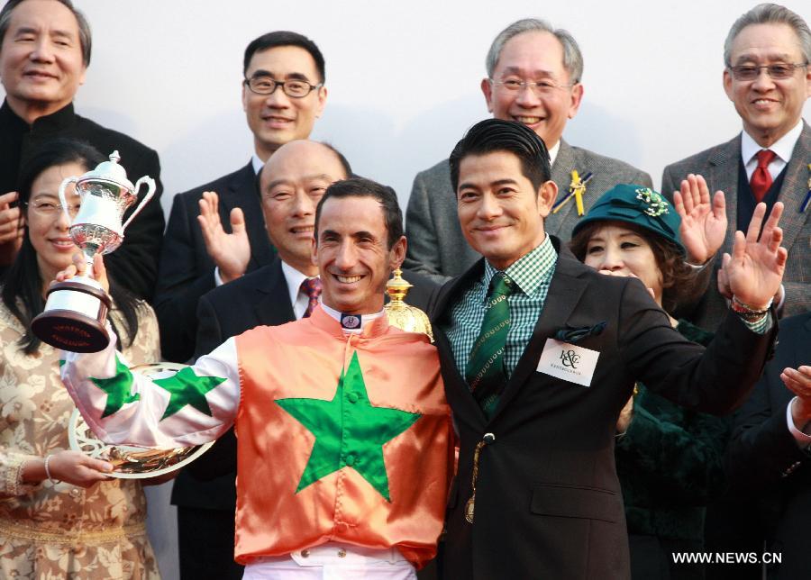 Singer Aaron Kwok (R, front) poses for a group picture after presenting the award to the winner of a horse racing activity in south China's Hong Kong, Jan. 27, 2013. (Xinhua/Jin Yi)
