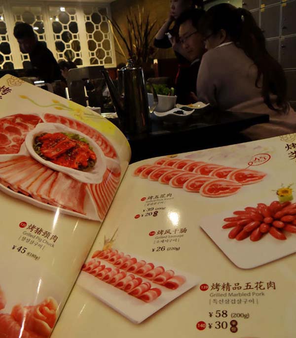 The menu of Han Na Shan Korean BBQ in Beijing shows the prices for a half portion of select dishes, Jan 27, 2013. (Photo/Xinhua) 