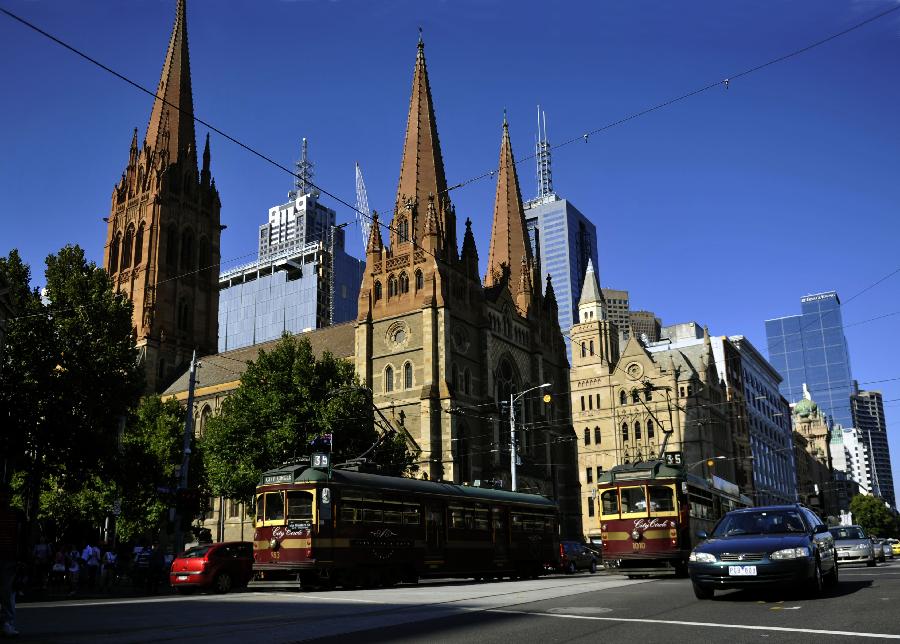 Two trams pass by the St. Paul's Cathedral in Melbourne, Australia, Jan. 28, 2013. Melbourne's trams network is one of the largest functioning tram networks in the world. Among all the routes, No. 35, the City Circle Tram provides a free and convenient way for visitors to see the sights of central Melbourne while experiencing a ride on one of the city's much loved heritage trams. (Xinhua/Chen Xiaowei)