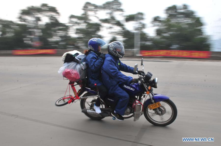 Migrant workers ride motorbikes on their way back home on the 321 National Highway in Wuzhou, south China's Guangxi Zhuang Autonomous Region, Jan. 29, 2013. Many Guangxi migrant workers working in south China's Guangdong Province got around the ticket buying predicament during the Spring Festival travel rush which lasts for forty days by riding back home thanks to the well-developed roads connecting Guangxi and Guangdong. (Xinhua/Huang Xiaobang)