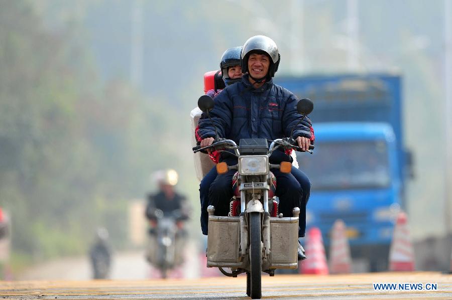 Migrant workers ride motorbikes on their way back home on the 321 National Highway in Wuzhou, south China's Guangxi Zhuang Autonomous Region, Jan. 29, 2013. Many Guangxi migrant workers working in south China's Guangdong Province got around the ticket buying predicament during the Spring Festival travel rush which lasts for forty days by riding back home thanks to the well-developed roads connecting Guangxi and Guangdong. (Xinhua/Huang Xiaobang) 