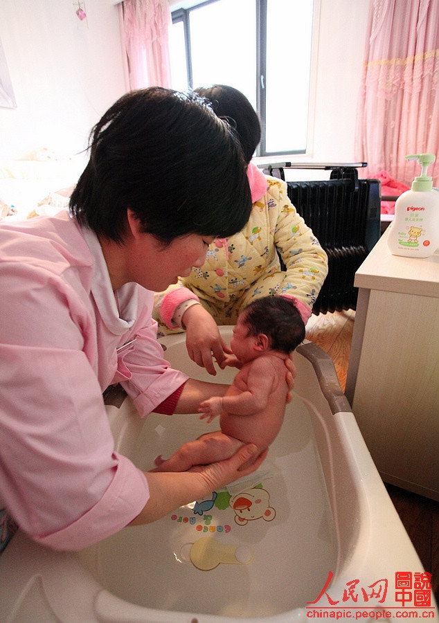 Zhang puts the baby into water. She lets the baby keep the posture when she was in the womb so that the baby can feel safe.