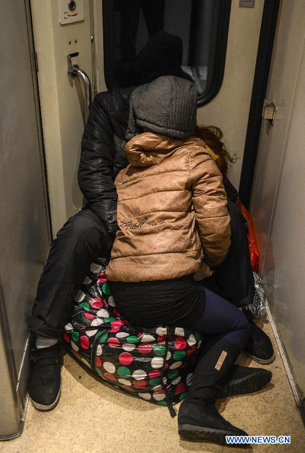 Passengers sleep on the train L8600 from Hangzhou, capital of east China's Zhejiang Province, to Fuyang, east China's Anhui Province, Jan. 29, 2013. The 40-day Spring Festival travel rush started on Jan. 26. The Spring Festival, which falls on Feb. 10 this year, is traditionally the most important holiday of the Chinese people. It is a custom for families to reunite in the holiday, a factor that has led to massive seasonal travel rushes in recent years as more Chinese leave their hometowns to seek work elsewhere. Public transportation is expected to accommodate about 3.41 billion travelers nationwide during the holiday, including 225 million railway passengers. (Xinhua/Han Chuanhao) 