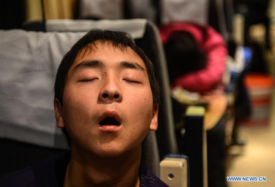 A passenger sleeps on the train L8600 from Hangzhou, capital of east China's Zhejiang Province, to Fuyang, east China's Anhui Province, Jan. 29, 2013. The 40-day Spring Festival travel rush started on Jan. 26. The Spring Festival, which falls on Feb. 10 this year, is traditionally the most important holiday of the Chinese people. It is a custom for families to reunite in the holiday, a factor that has led to massive seasonal travel rushes in recent years as more Chinese leave their hometowns to seek work elsewhere. Public transportation is expected to accommodate about 3.41 billion travelers nationwide during the holiday, including 225 million railway passengers.(Xinhua/Han Chuanhao) 