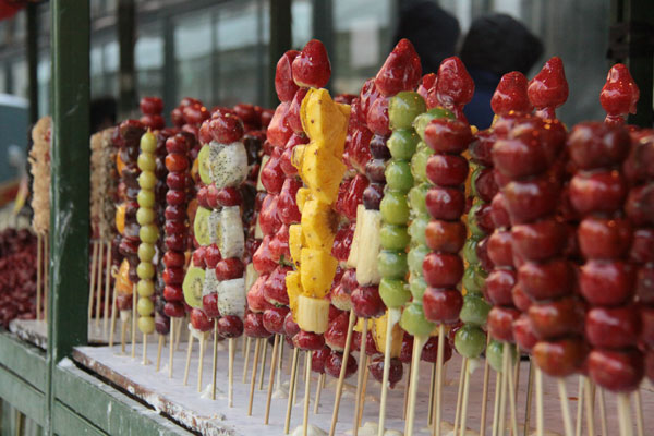 "Tanghulu" (crispy, sugar-coated fruit on a stick) is sold on Central Street in Harbin, northeast China's Heilongjiang Province, on December 17, 2012. [Photo: CRIENGLISH.com] 