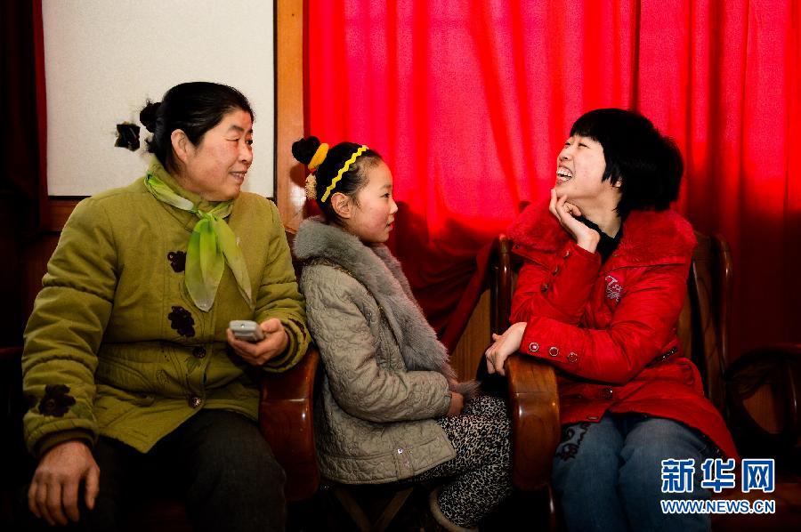 Photo taken on Jan 25, 2013 shows Liu Xiaolin (R) describing the beautiful world in a novel she wrote to her mother and niece. (Xinhua/Guo Xulei)