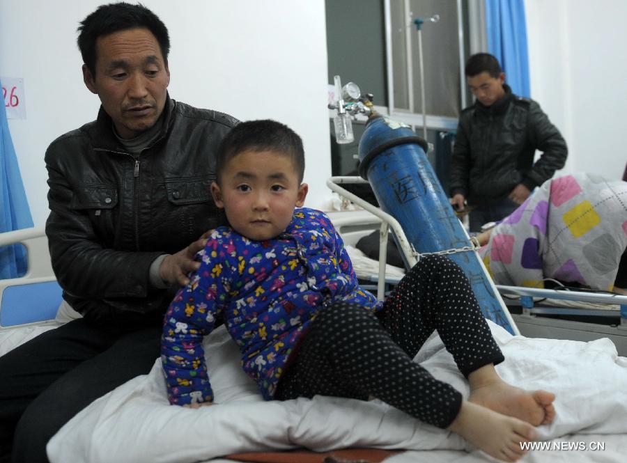 A four-year-old boy (front) who survived the bus crash receives medical treatment in a hospital in Ningxian County of Qingyang City in northwest China's Gansu Province, Feb. 2, 2013. An overloaded bus caught fire after falling into a ravine here on Friday. Eighteen people have been confirmed dead and 34 others injured in the accident after more bodies were recovered from the wreckage, government sources said Saturday. (Xinhua/Nie Jianjiang)