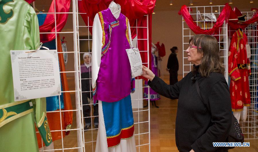 A visitor looks at costumes of China's Naxi ethnic group during the Chinese Cultural Heritage Day event at the Royal Ontario Museum in Toronto, Canada, Feb. 2, 2013. One of the most prominent museums in the Canadian city of Toronto was transformed into a galore of Chinese artistry on Saturday, presenting a live snake display, an ethnic costume display and a diverse array of Chinese-themed performances. (Xinhua/Zou Zheng)