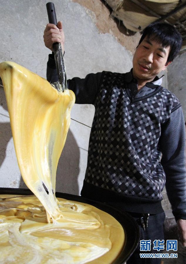 A man in a workshop in Henan province mixes the syrup for sesame candies. The syrup usually takes five hours to prepare according to the worker. (Xinhua/ Qin Linlin)
