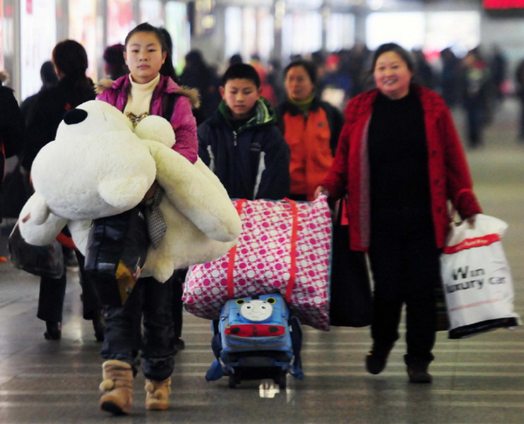 A girl carries a toy bear at Wuchang Railway Station in Wuhan, capital of Central China's Hubei province on Jan 21, 2013. For many the bears add some fun to the crowded or perhaps tiresome journey. Public transportation is expected to accommodate about 3.41 billion travelers nationwide during the holiday, including 225 million railway passengers. (Photo/Xinhua)