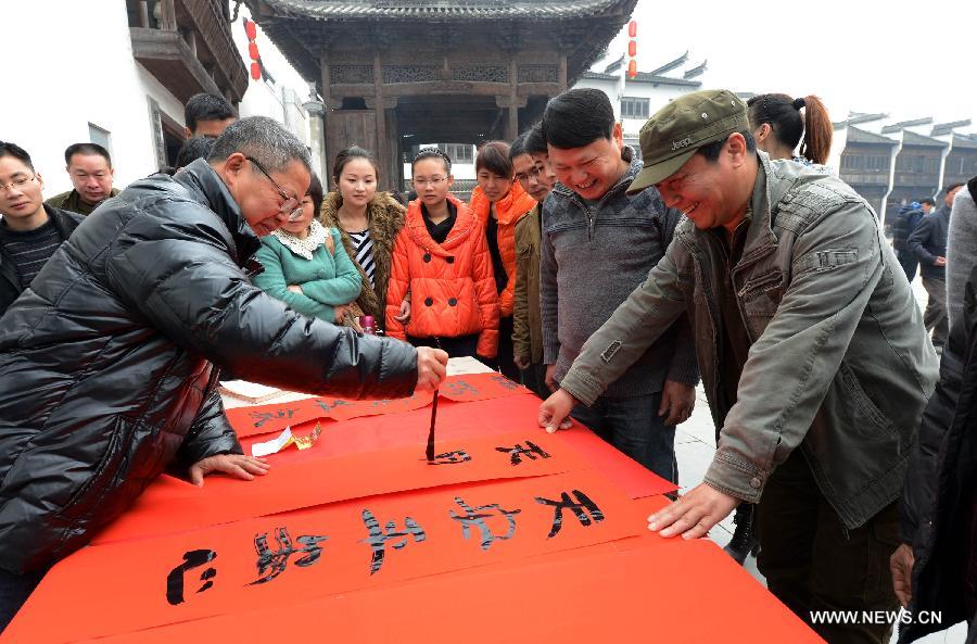 Zhan Ruitian (L, front), a calligraphy enthusiast, writes Spring Festival Couplets in Jiangwan Village of Wuyuan County, east China's Jiangxi Province, Feb. 4, 2013. Various traditional activities were held in Wuyuan to celebrate "Lichun", literally meaning the beginning of the spring, as well as the Xiaonian Festival which falls on the 23rd or 24th day of the 12th month of the Chinese traditional lunar calendar. (Xinhua/Song Zhenping)