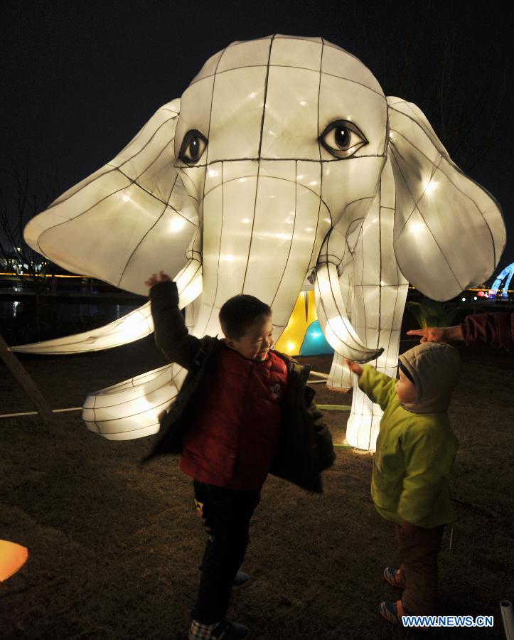 Children play in front of festive lanterns during a lantern show in Changsha, capital of central China's Hunan Province, Feb. 5, 2013. The lantern show was held to greet the upcoming Spring Festival, or the Chinese Lunar New Year, which falls on Feb. 10 this year. (Xinhua/Li Ga