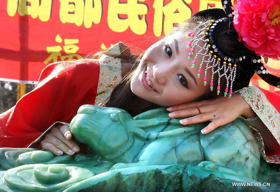 Photo taken on Jan. 31, 2011 shows a woman lying beside a jade handicraft of rabbit at a temple fair in Zhengzhou, capital of central China's Henan Province. 2011 is the Year of the Rabbit in the Chinese Zodiac. Chinese Zodiac is represented by 12 animals to record the years and reflect people's attributes, including the rat, ox, tiger, rabbit, dragon, snake, horse, sheep, monkey, rooster, dog and pig. (Xinhua/Wang Song) 