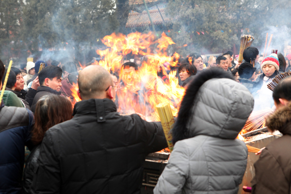 People burn incense to pray for good fortune on the first day of the Chinese Lunar New Year at Yonghegong Lama Temple, in Beijing Feb 10, 2013. (Photo/chinadaily.com.cn)