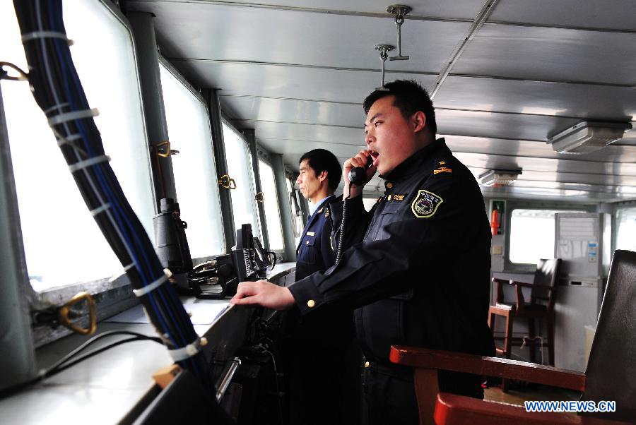 Zhu Linxing (R), head of the law enforcement unit aboard the Haijian 137, a Chinese marine surveillance ship, communicates with Japanese ships during a patrol mission in the territorial waters surrounding the Diaoyu Islands in the East China Sea on Feb. 10, 2013. A Chinese marine surveillance fleet, which includes the Haijian 50, Haijian 51, Haijian 66 and Haijian 137 ships, carried out regular patrol missions in the territorial waters surrounding the Diaoyu Islands on Sunday, the first day of the 2013 Spring Festival. (Xinhua/Zhang Jiansong)