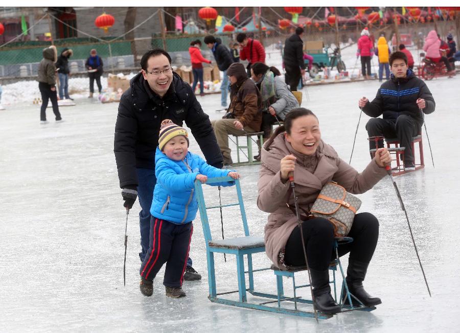 A family plays at the Shichahai Lake Ice Rink on the first day of the Chinese Lunar New Year in Beijing, capital of China, Feb. 10, 2013. Many people here chose to spend the first day of the Chinese Lunar New Year on the ice. (Xinhua/Chen Xiaogen) 