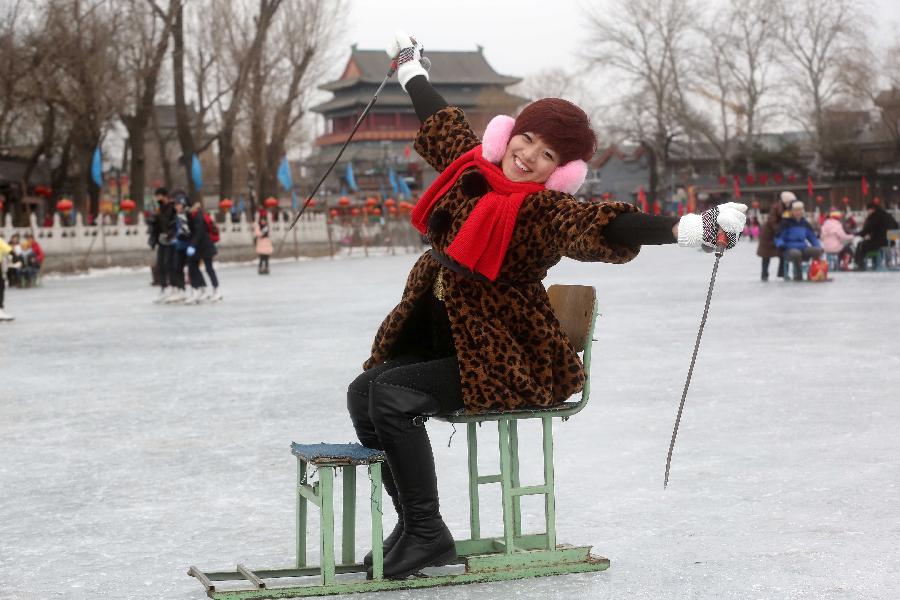 A girl enjoys herself on a sled at the Shichahai Lake Ice Rink on the first day of the Chinese Lunar New Year in Beijing, capital of China, Feb. 10, 2013. Many people here chose to spend the first day of the Chinese Lunar New Year on the ice. (Xinhua/Chen Xiaogen)