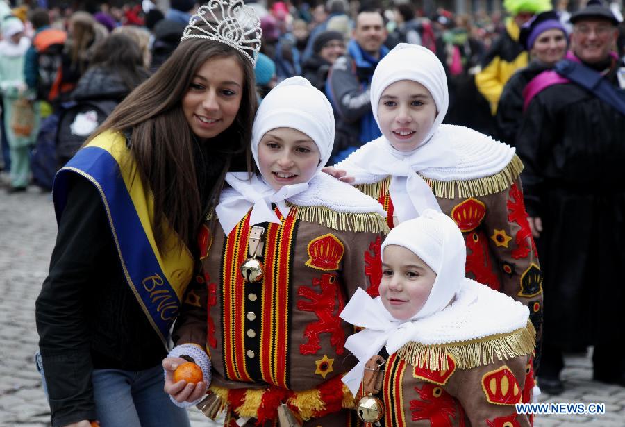 Miss Binche (1st L) poses with young Gilles during the Binche Carnival in Binche, Belgium, Feb. 12, 2013. Binche Carnival was inscribed on the Representative List of the Intangible Cultural Heritage of Humanity by UNESCO in 2003. (Xinhua/Wang Xiaojun) 