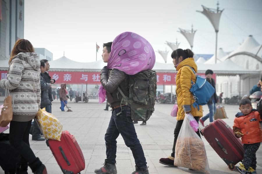 Passengers are seen at a train station in Fuyang of east China's Anhui Province, Feb. 13, 2013. Some people in China started the return trips to their workplaces as the Spring Festival holiday coming to its conclusion. (Xinhua/Guo Chen) 