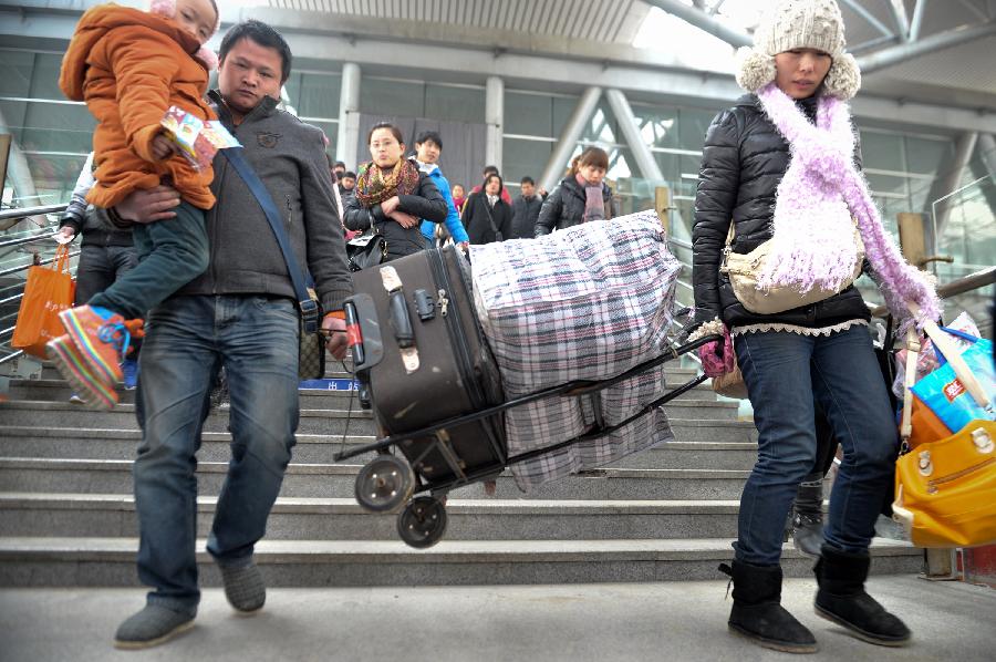 Passengers are seen at a train station in Fuyang of east China's Anhui Province, Feb. 13, 2013. Some people in China started the return trips to their workplaces as the Spring Festival holiday coming to its conclusion. (Xinhua/Guo Chen) 