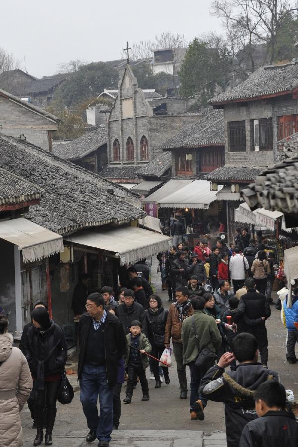  Tourists are seen on the street of Qingyan Town in Guiyang, capital of southwest China's Guizhou Province, Feb. 13, 2013. Large amount of tourists visited the time-honored Qingyan Town during the Spring Festival holiday. (Xinhua/Ou Dongqu)  