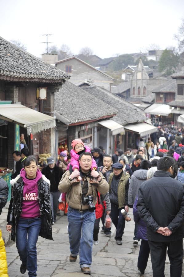 Tourists are seen on the street of Qingyan Town in Guiyang, capital of southwest China's Guizhou Province, Feb. 13, 2013. Large amount of tourists visited the time-honored Qingyan Town during the Spring Festival holiday. (Xinhua/Ou Dongqu) 