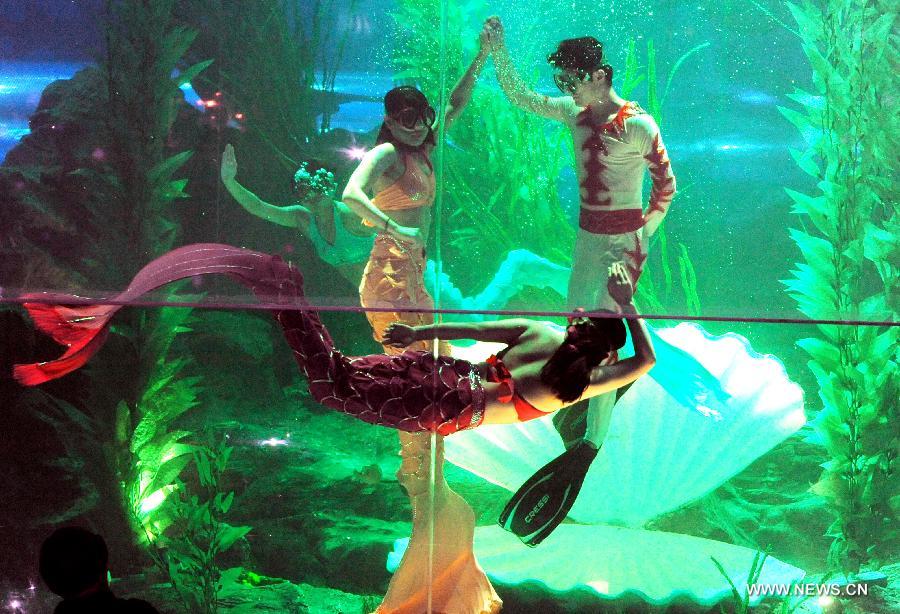 Performers dance in water at Qingdao Underwater World in Qingdao, east China's Shandong Province, Feb. 15, 2013. During the Spring Festival holidays, an underwater performance telling the story of a mermaid and a prince attracted many visitors in Qingdao. Visual, audio and electronical technologies were applied to the performance. (Xinhua/Li Ziheng) 