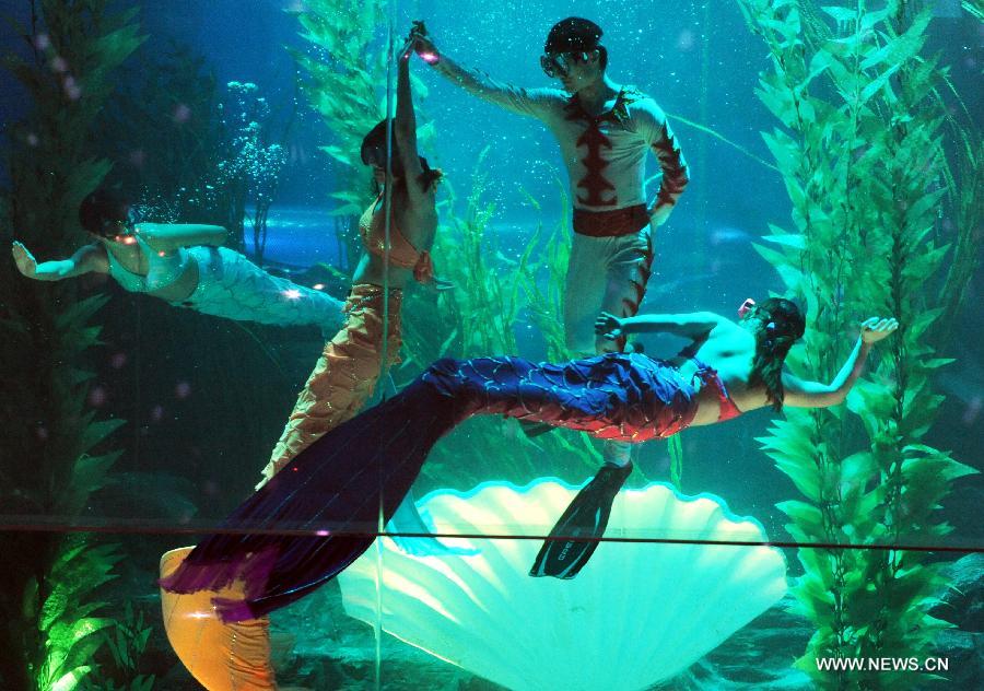 Performers dance in water at Qingdao Underwater World in Qingdao, east China's Shandong Province, Feb. 15, 2013. During the Spring Festival holidays, an underwater performance telling the story of a mermaid and a prince attracted many visitors in Qingdao. Visual, audio and electronical technologies were applied to the performance. (Xinhua/Li Ziheng) 
