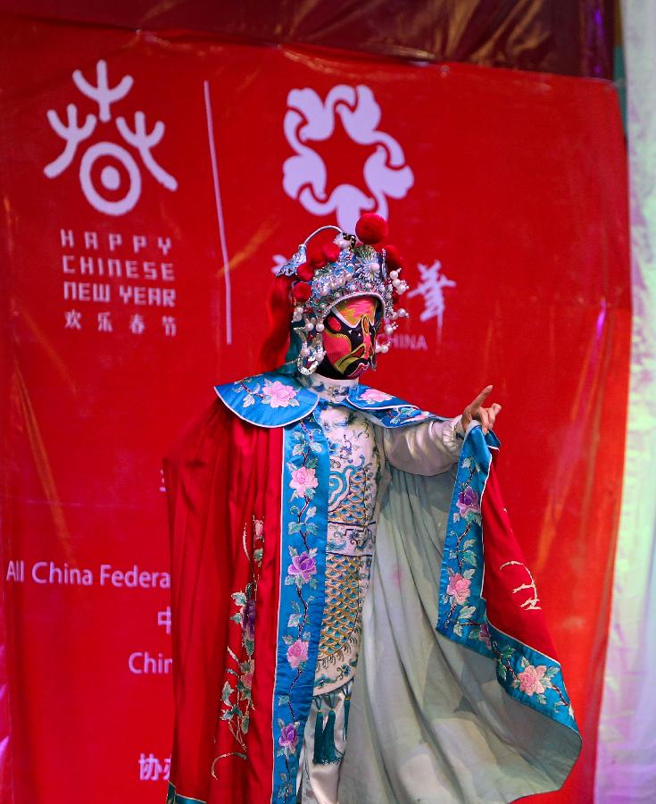 Actress Zhang Yueying performs "changing face" during the performances of the Embrace China Art Group of the All-China Federation of Returned Overseas Chinese in Nairobi, Kenya, Feb. 16, 2013. (Xinhua/Meng Chenguang) 
