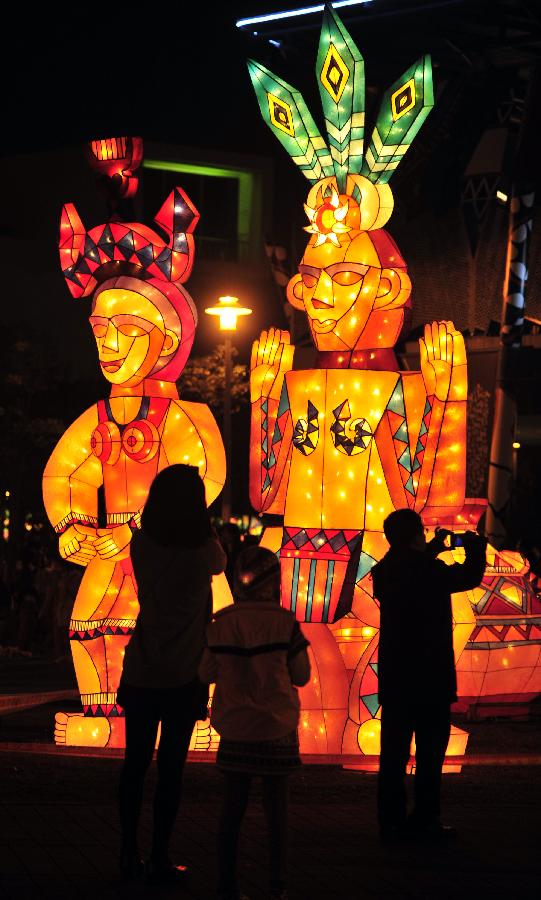 Visitors view lanterns during a trial lighting for the 2013 Taipei lantern festival in Taipei, southeast China's Taiwan, Feb. 16, 2013. The lantern festival, which is to celebrate the Chinese traditional Lantern Festival, will kick off on Feb. 21. The Lantern Festival falls on the 15th day of the first month of the Chinese lunar calendar, or Feb. 24 this year. (Xinhua/Wu Ching-teng) 