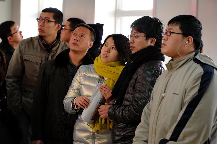 Job applicants browse the employment information at a job fair in Changchun, capital of northeast China's Jilin Province, Feb. 20, 2013. Over 2,000 job positions from some 100 companies were provided on the job fair held here on Wednesday. (Xinhua/Zhang Nan) 