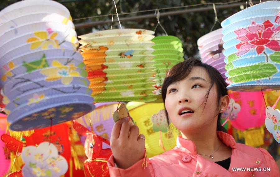 A girl chooses lanterns at a market in Huaibei, east China's Anhui Province, Feb. 20, 2013. An annual lantern sales boom appeared with the approaching of the Lantern Festival which falls on Feb. 24 this year. (Xinhua/Wang Haoyu) 