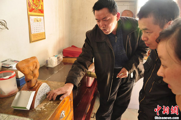 An undated photo shows Luo demonstrates the incredible process to two onlookers. (Chinanews.com)