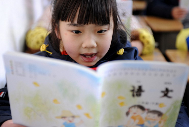 A second-grade student in a primary school in Nanjing, Jiangsu province, reads in class on Thursday, the first day of the new semester for around 800,000 students in the city's kindergartens, primary and secondary schools. The starting day, scheduled for Tuesday, was postponed due to a sudden snowfall that blanketed the province late on Monday night. (Photo/Xinhua) 