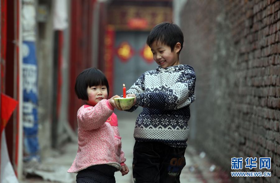 Photo taken on Feb. 20, 2013 shows two children playing a radish lantern in Tangyin county, Henan province. (Xinhua/Zhao Dongshan)