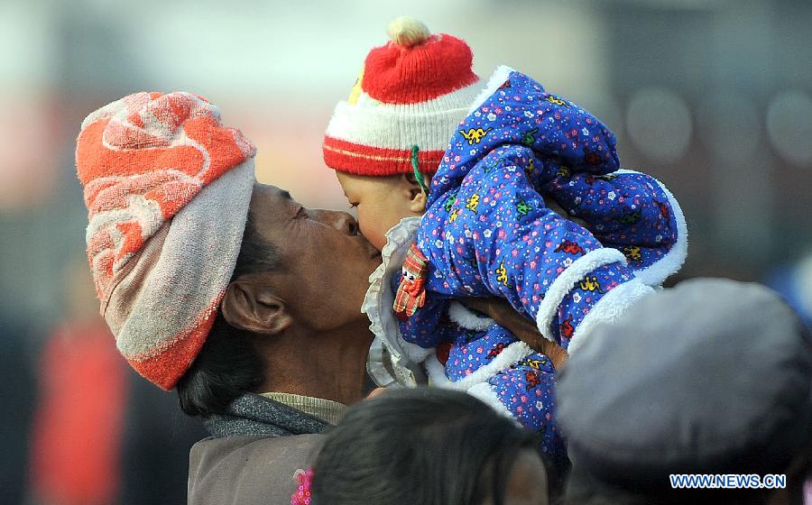 A passenger kisses his child at the railway station in Chengdu, capital of southwest China's Sichuan Province, Feb. 22, 2013. As the number of travellers rises before the Lantern Festival, many children went back with their parents back to the workplaces. (Xinhua/Xue Yubin)