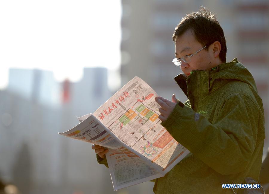  A job seeker reads employment information at a job fair in Beijing, capital of China, Feb. 23, 2013. About 25,000 job opportunities were offered at the job fair. (Xinhua/Luo Xiaoguang) 
