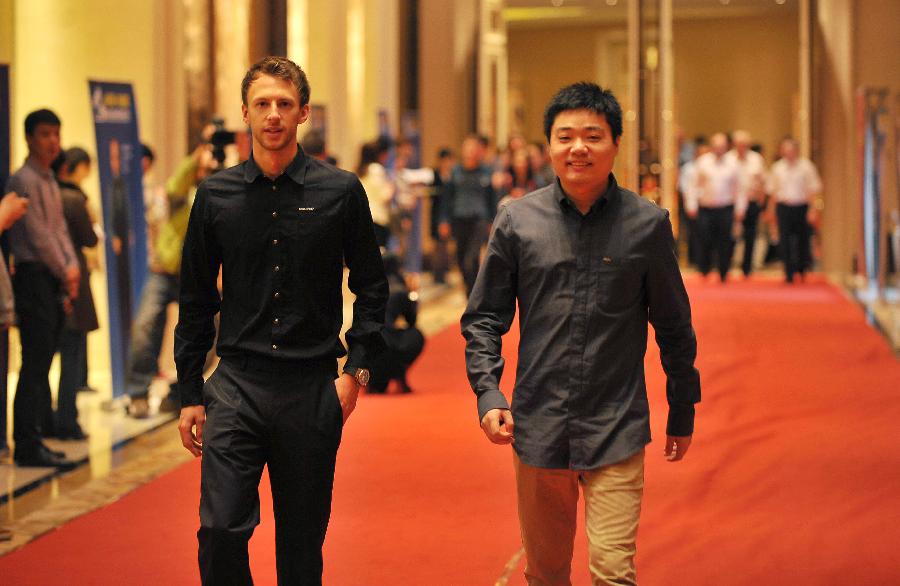 China's Ding Junhui (R) and Judd Trump of England arrive on the red carpet before the news conference for the Haikou World Open snooker tournament in Haikou, south China's Hainan Province, Feb. 24, 2013. (Xinhua/Guo Cheng)