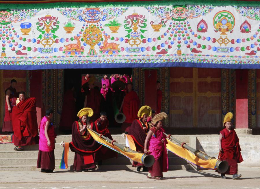 Buddhist monks carry long horns as they head for a ritual dance which prays for good fortune and harvest at the Labrang Monastery in Xiahe County, Gannan Tibetan Autonomous Prefecture, northwest China's Gansu Province, Feb. 23, 2013. The Labrang Monastery is among the six great monasteries of the Geluk school of Tibetan Buddhism. (Xinhua/Shi Youdong)