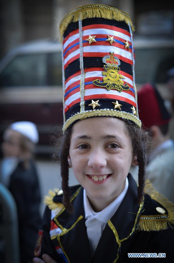 An Ultra-Othordox Jewish boy dressed in disguises walks in a street during Purim festival, a Jewish colorful and popular holiday, in Jerusalem, on Feb. 25, 2013. In Jerusalem, Purim was celebrated from sunset on Sunday, Feb. 24, until sunset on Monday, Feb. 25, one day later than it is in the rest of the world. (Xinhua/Yin Dongxun) 