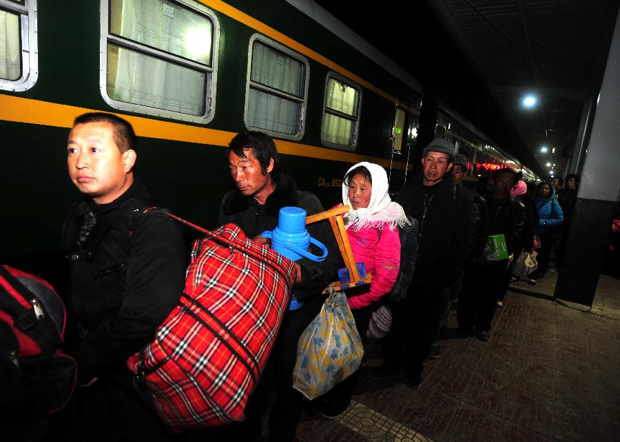 Migrant workers queue to get on a train to Urumqi, capital of northwest China's Xinjiang Uygur Autonomous Region, at Longxi Railway Station in Longxi County, northwest China's Gansu Province, Feb. 26, 2013. Many migrant workers started their journey to work away home after the Chinese Spring Festival holidays. (Xinhua/Nie Jianjiang) 