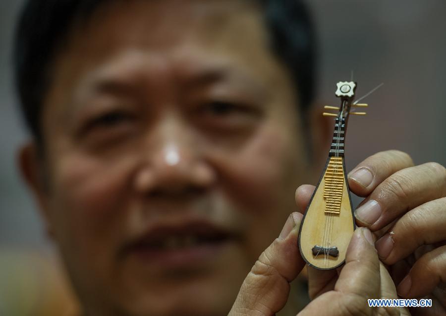 An artist shows a mini carving work during the 6th China (Chongqing) Arts and Crafts Fair in southwest China's Chongqing Municipality, Feb. 28, 2013. The fair, with the participation of many exhibitors from both home and abroad, opened here Thursday. (Xinhua/Chen Cheng) 