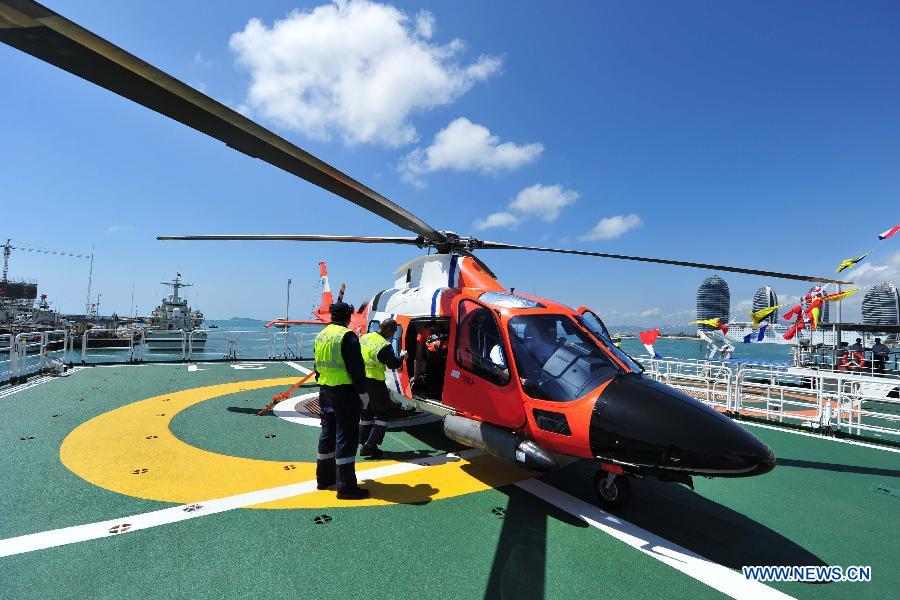 Staff members examine the helicopter carried by marine patrol ship "Haixun 31" before it sails out of the port of Sanya, south China's Hainan Province, Feb. 28, 2013. A formation of three marine patrol ships "Haixun 21", "Haixun 31" and "Haixun 166" started their coast guard mission in South China Sea on Thursday, a second one by the national Maritime Safety Administration at this water area in 2013. The first mission was conducted from Jan. 15, 2013 to Jan. 17, 2013. (Xinhua/Hou Jiansen)