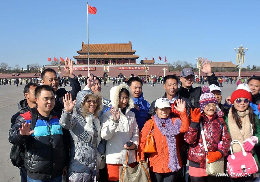 Tourists pose for a photo on the Tian'anmen Square during a sunny day in Beijing, capital of China, March 1, 2013. The first session of the 12th National People's Congress (NPC) and the first session of the 12th National Committee of the Chinese People's Political Consultative Conference (CPPCC) will open on March 5 and March 3 respectively. (Xinhua/Wang Song)