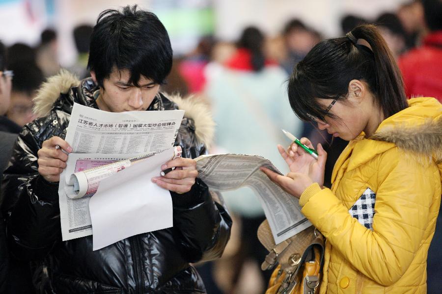 Job seekers read employment information at a job fair in Nanjing, capital of east China's Jiangsu Province, March 2, 2013. More than 20,000 job opportunities were offered at the job fair. (Xinhua/Wang Xin) 