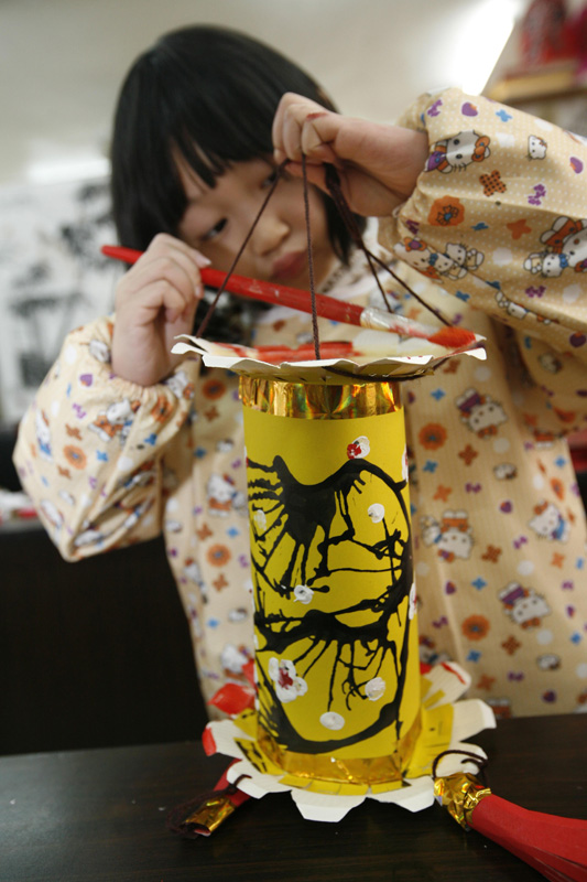 A child makes a lantern using waste materials in Xiangyang of Hubei on Feb. 24, 2013. (Xinhua/Gongbo)