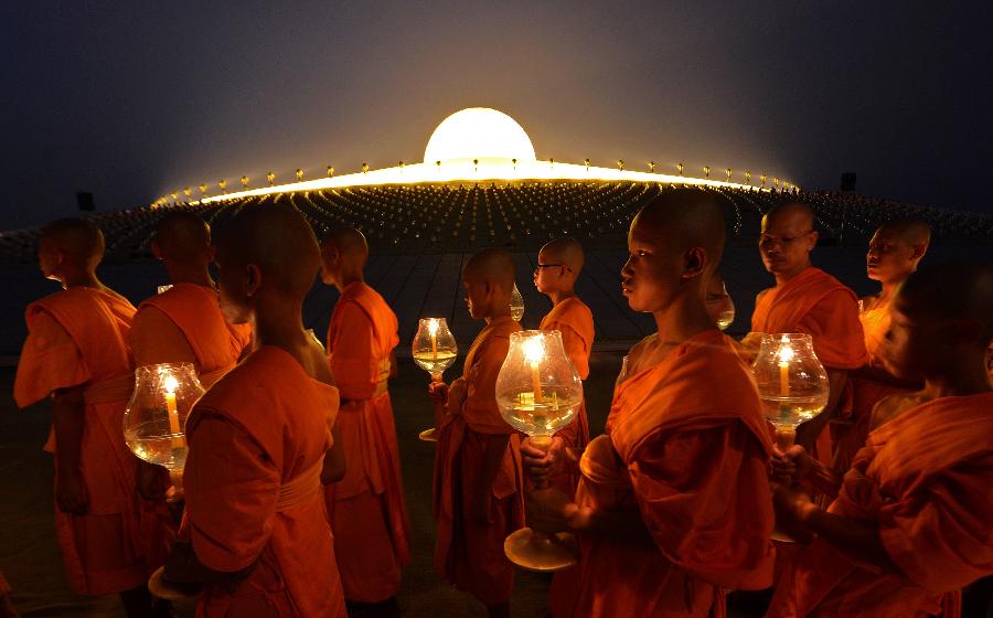 Buddhist monks carry candles as they pray at the Wat Phra Dhammakaya temple in Pathum Thani province, north of Bangkok on Makha Bucha Day February 25, 2013.  (Xinhua/AFP Photo)