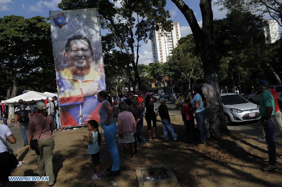 Residents walk past a poster of Venezuelan President Hugo Chavez on a street in Caracas, capital of Venezuela, on Mar. 2, 2013. Venezuela's ailing President Hugo Chavez is undergoing chemotherapy in the capital's military hospital, Vice President Nicolas Maduro said Friday, calling for respect for Chavez and his family. (Xinhua/Mauricio Valenzuela) 