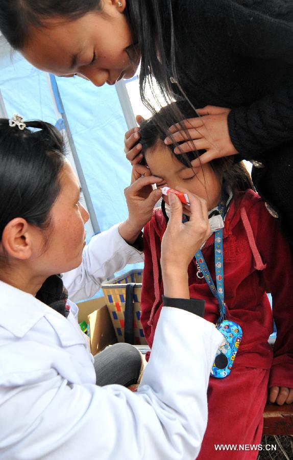 A doctor applys ointment to a girl at Qiandian Village of Liantie Township in Eryuan County of Dali Bai Autonomous Prefecture, southwest China's Yunnan Province, March 4, 2013. A 5.5-magnitude earthquake hit Eryuan County on March 3. Thirty people have been confirmed injured, while some 21,000 people have been evacuated. (Xinhua/Lin Yiguang) 