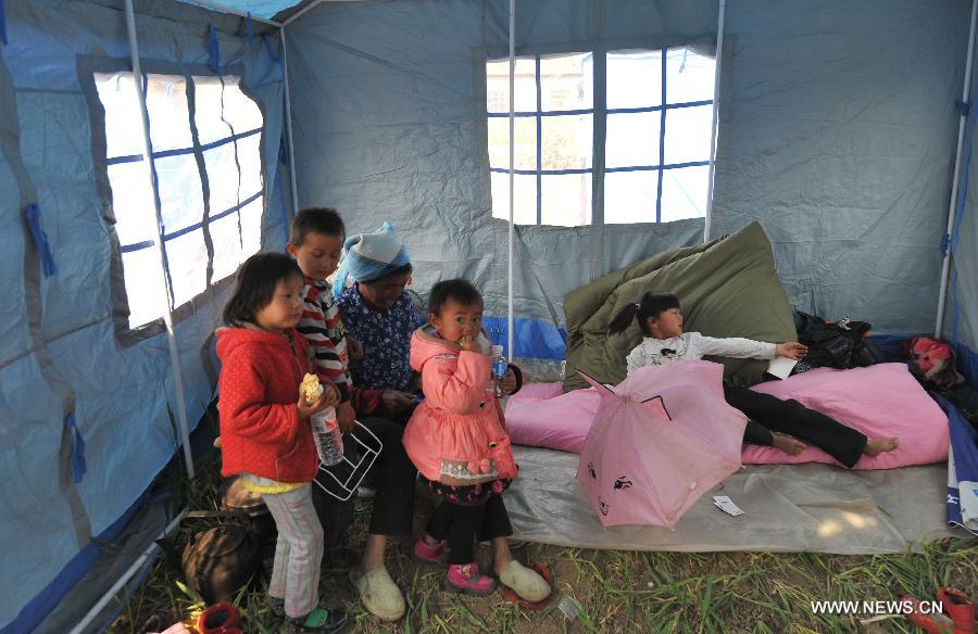 People stay in a relief tent at Qiandian Village of Liantie Township in Eryuan County of Dali Bai Autonomous Prefecture, southwest China's Yunnan Province, March 4, 2013. A 5.5-magnitude earthquake hit Eryuan County on March 3. Thirty people have been confirmed injured, while some 21,000 people have been evacuated. (Xinhua/Lin Yiguang) 